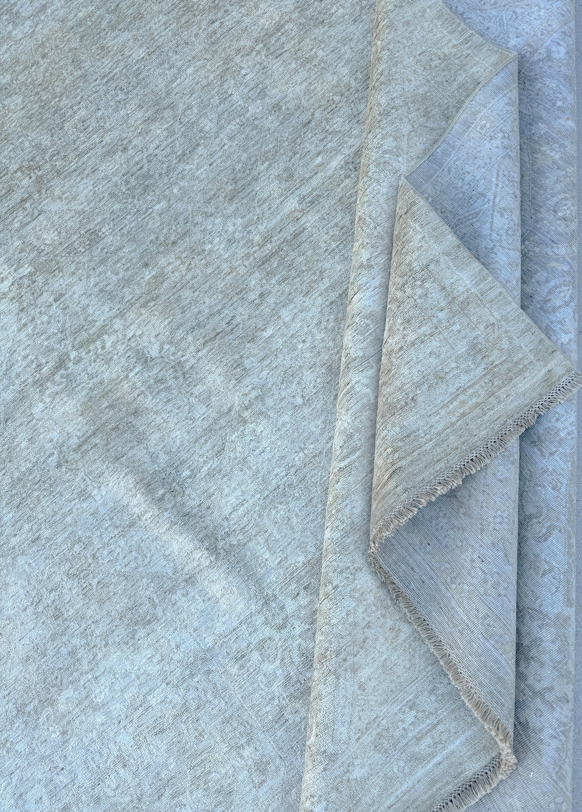Folded blue-gray handmade Afghan wool rug, close-up of the weave