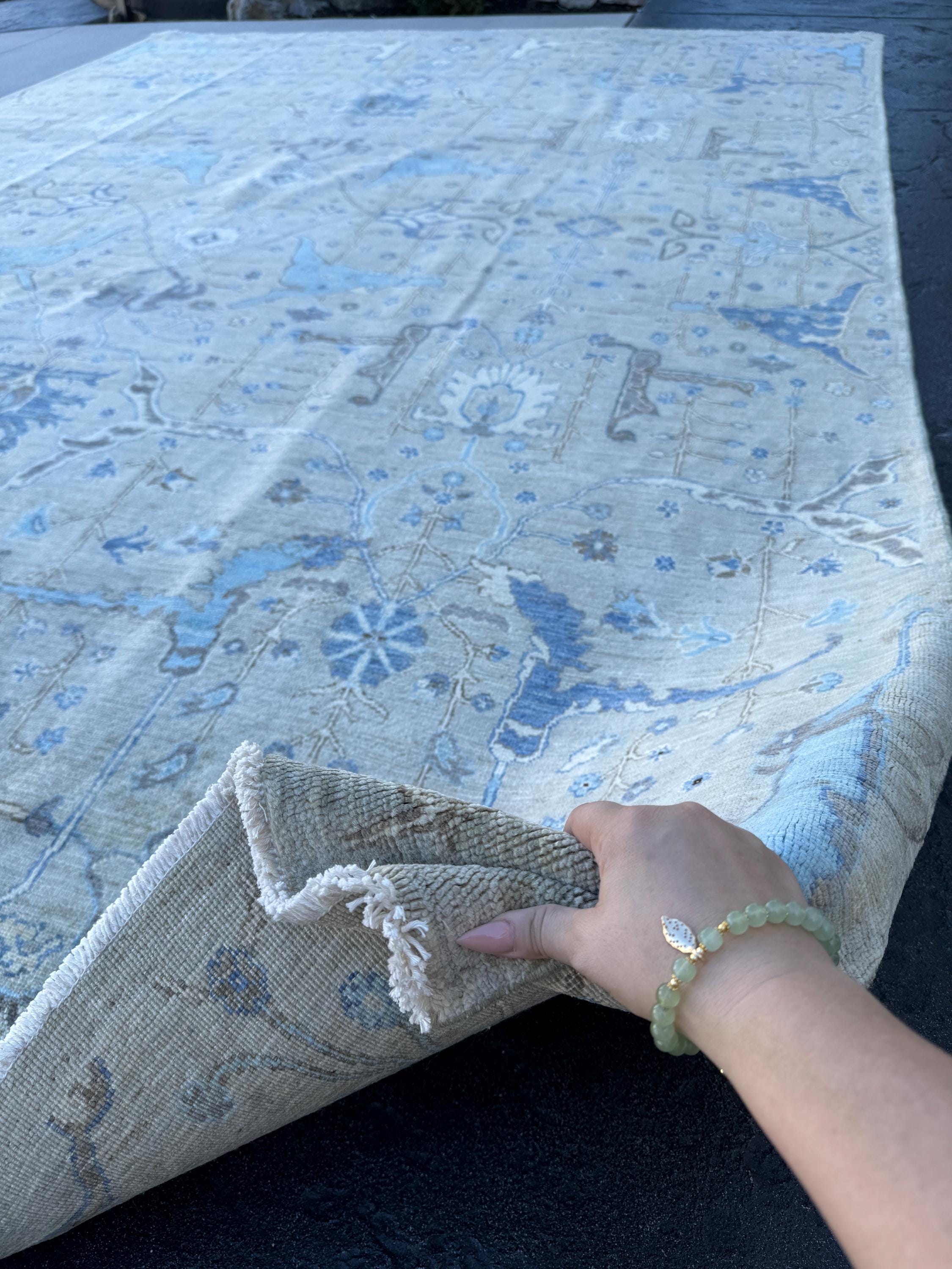 May include: A light blue and beige area rug with a floral and paisley design. The rug has a subtle distressed look, and the edges are frayed. The rug is made of a soft, plush material and is perfect for adding a touch of elegance to any room.